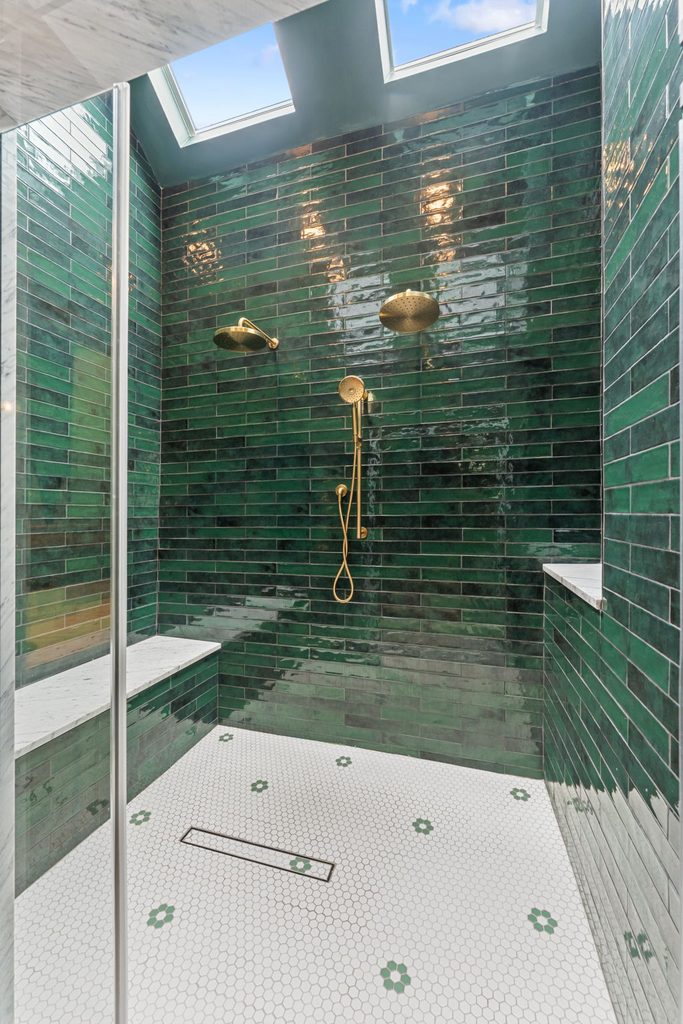 A remodeled small 5x8 Philadelphia bathroom featuring a sleek tub-to-shower conversion with a frameless glass enclosure and large-format wall tile.